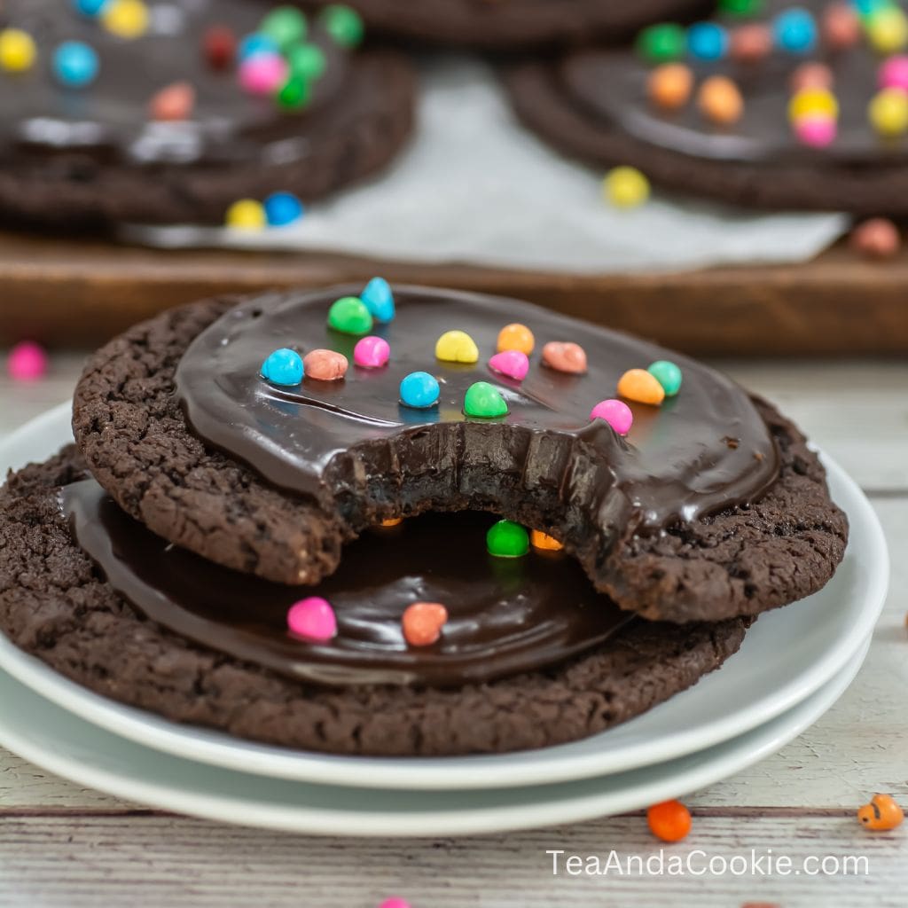 A picture of Cosmic Brownie Cookies. A deep chocolate cookie topped with a chocolate ganache and colorful candies.