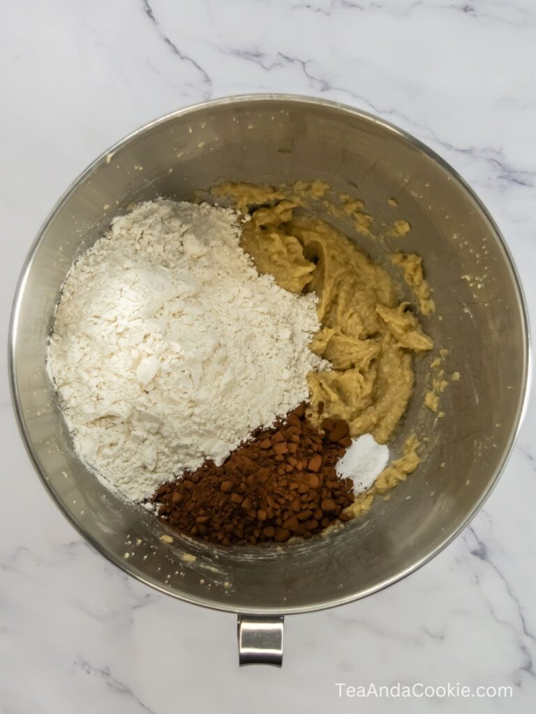 A picture of adding flour, cocoa powder, salt and baking soda to the wet ingredients in a bowl.