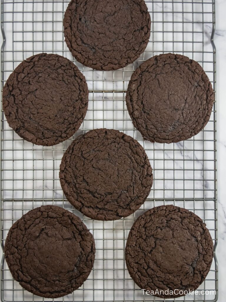 A wire rack with Cosmic Brownie Cookies that have just come out of the oven