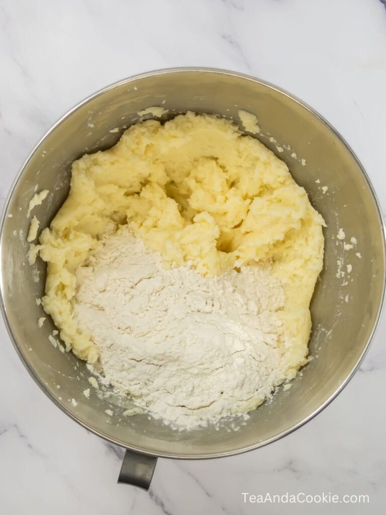 A bowl of creamed ingredients with flour added on top