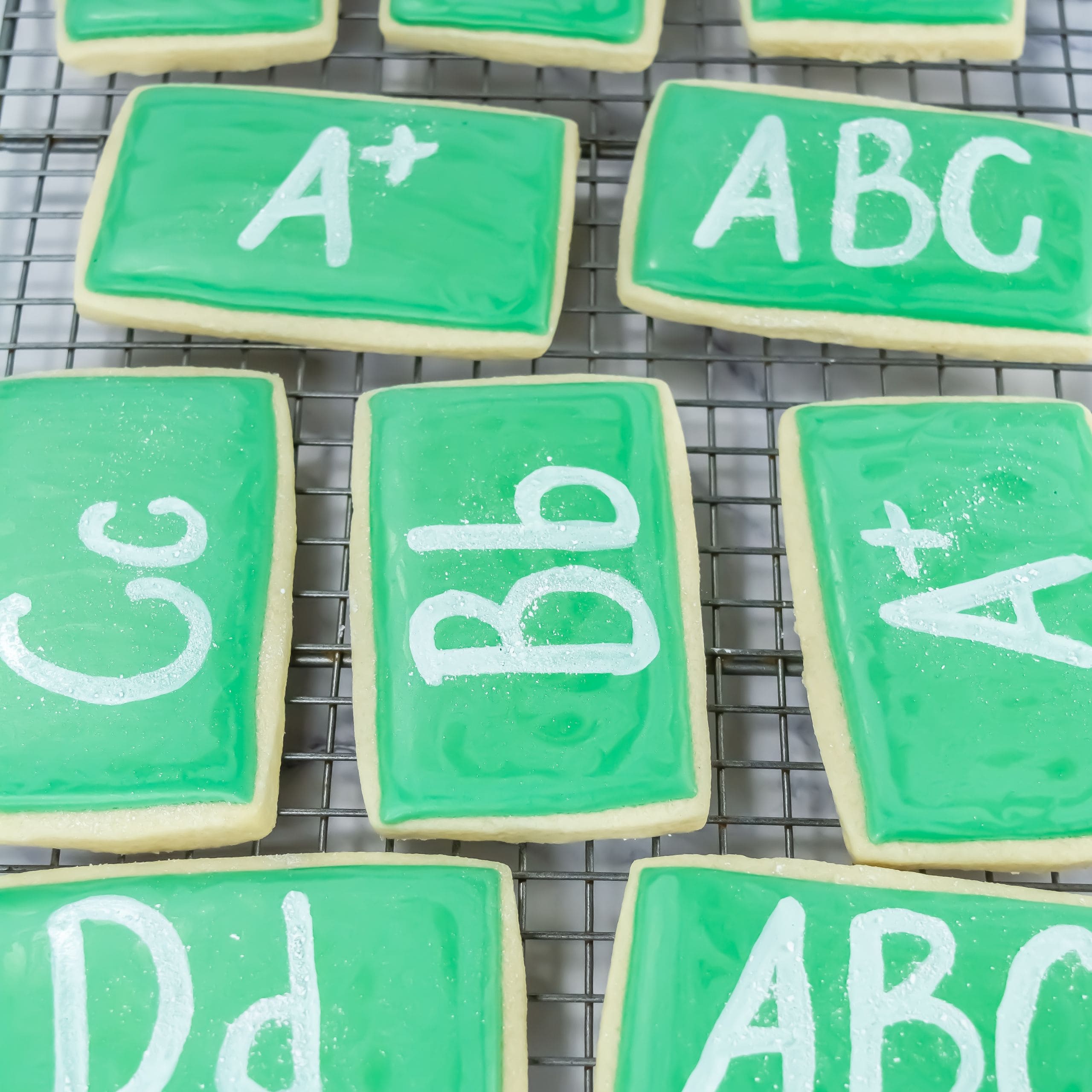 A wire rack with chalkboard cookies on it