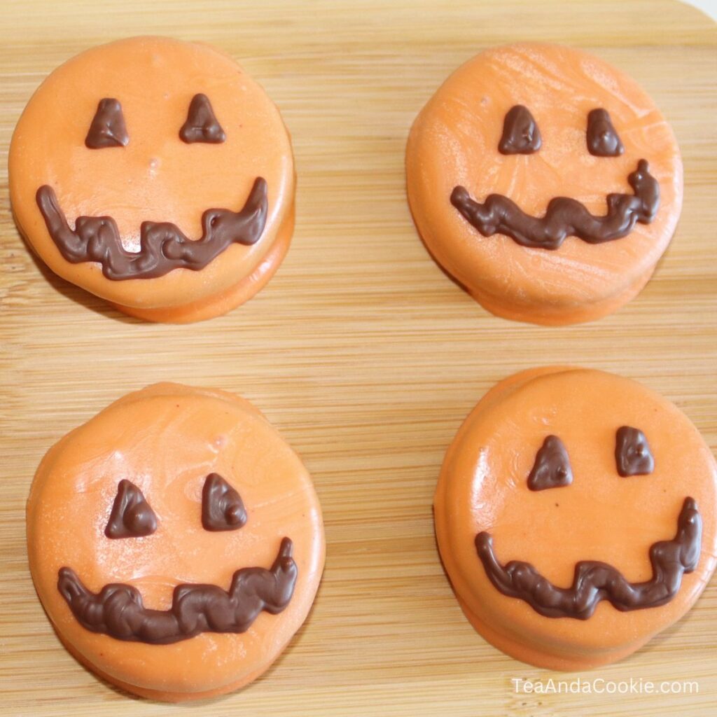 Chocolate covered Oreo pumpkins with orange chocolate and brown faces