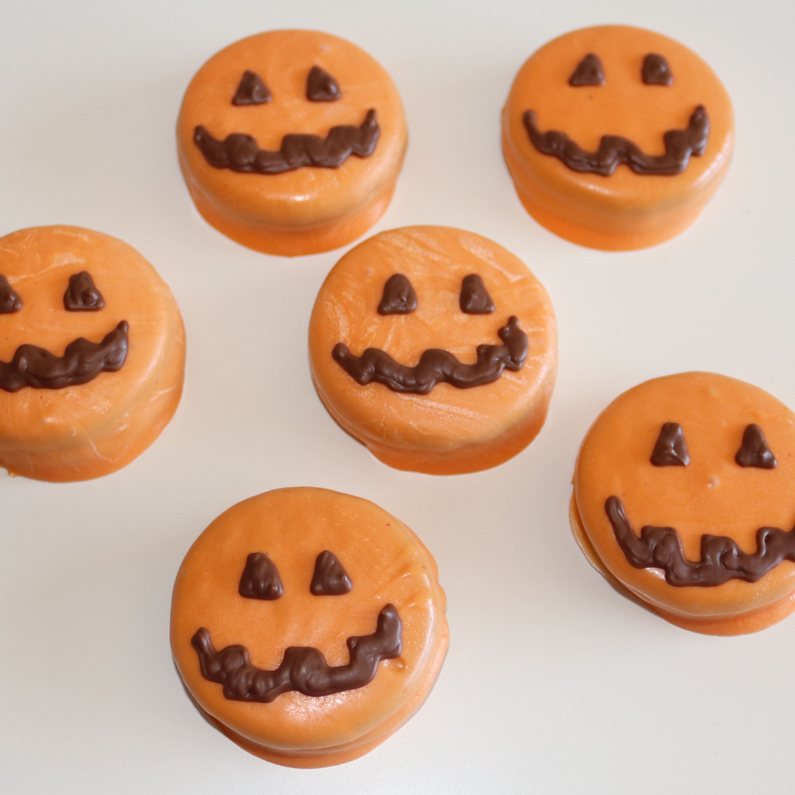 Orange pumpkins with chocolate Jack O Lantern faces
