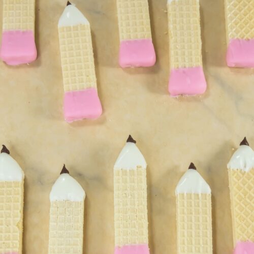 Pencil wafer cookies on parchment paper.