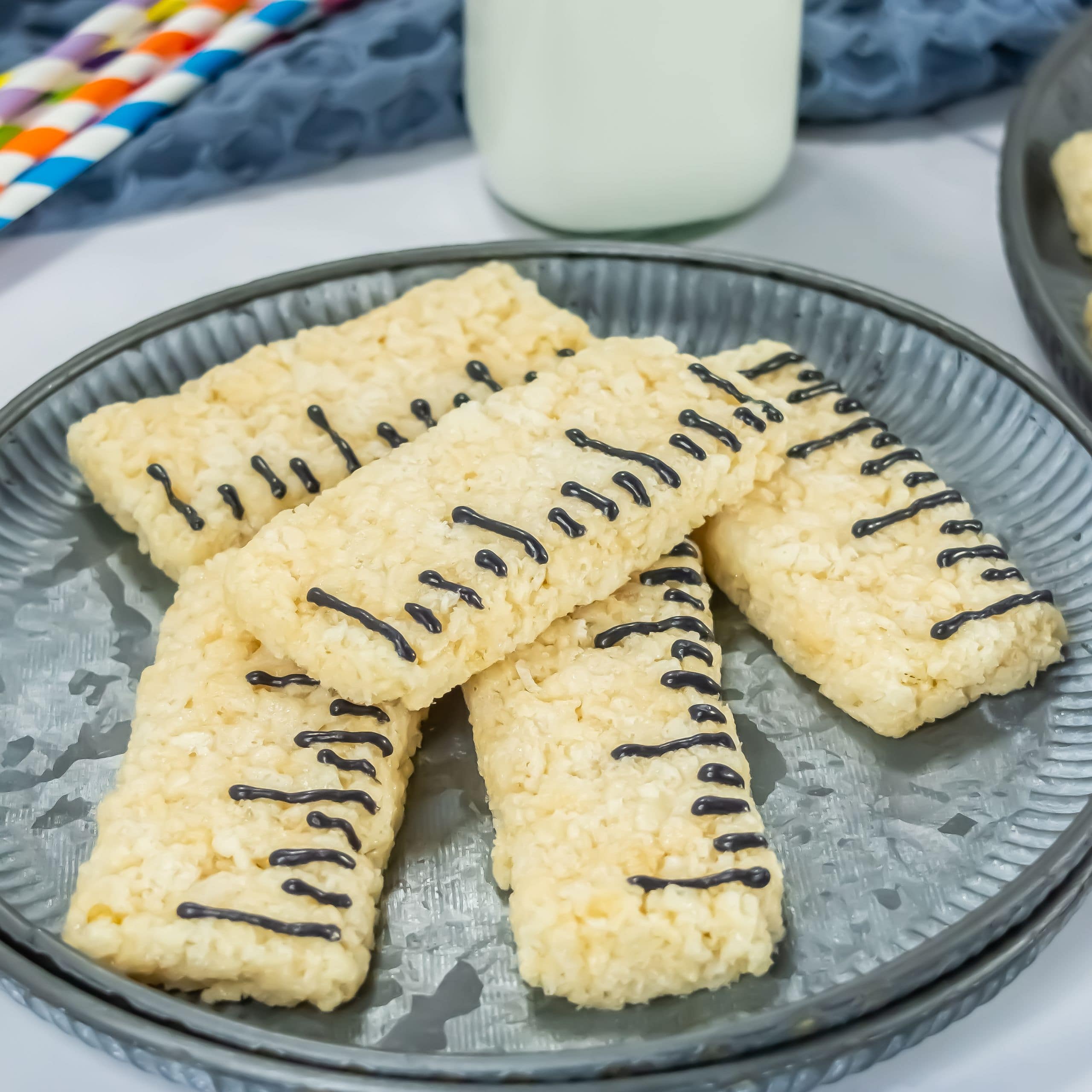 A gray plate with ruler Rice Krispie treats on it.