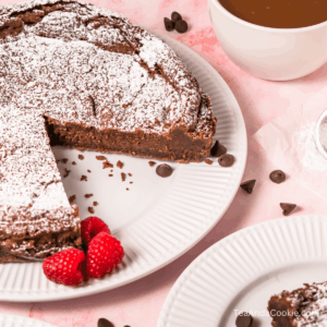 A plate of chocolate cake with a slice cut out.